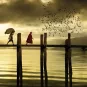 Hommes traversant un pont sous un coucher de soleil