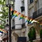 Décoration composée de banderoles triangulaires aux couleurs des drapeaux LGBTQ, suspendues aux balcons. Paris, France.